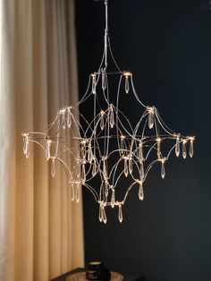 a chandelier with lights hanging from it's sides in front of a window