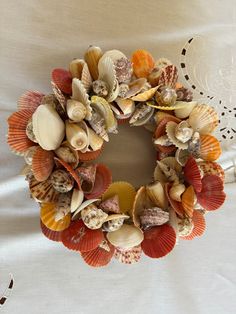 a wreath made out of seashells sits on a bed