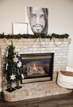 a mantel with a fireplace and christmas decorations on it, along with a fire place