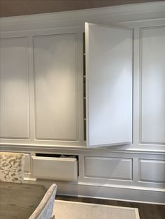 an empty kitchen with white cabinets and drawers