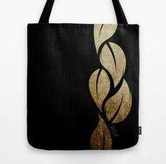 a black and gold tote bag with an abstract swirl design on it's side