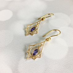 "Art Deco lovers here are purple Amethyst and gold earrings! So often we see Art Deco designs that are only red and gold but I also make Art Deco with many gemstones. These sweet earrings are lightweight and easy to wear. The faceted Amethyst stones are set in Vermeil gold that dangle freely within a Vermeil gold Art Deco charm that has a soft brushed finish. They hang 1.5 inches on Vermeil gold ear wires with a gold accent. These also make a wonderful gift for someone born in February since Ame Art Deco Amethyst Jewelry Gift, Art Nouveau Purple Jewelry For Gift, Purple Art Nouveau Jewelry For Gift, Purple Art Nouveau Jewelry Gift, Art Deco Jewelry 1920s, Art Deco Inspired Jewelry, February Gift, 1920s Jewelry, Spinel Jewelry