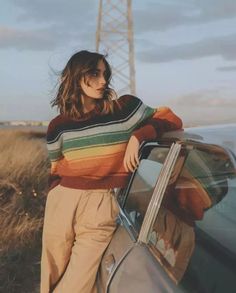 a woman leaning on the door of a car