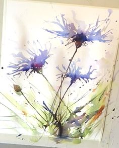 a person is painting flowers with watercolors