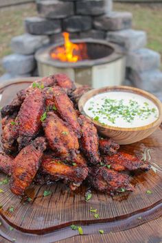 some fried food is on a plate next to a bowl of ranch dressing and fire pit