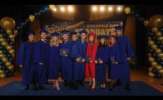 a group of people in graduation gowns posing for a photo