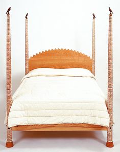 a bed with an intricate headboard and foot board made out of bamboo sticks, on a white background