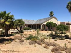 a house in the desert surrounded by palm trees