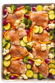 chicken and vegetables in a baking pan with broccoli, cauliflower, zucchini