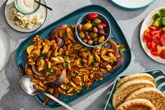 an assortment of food is displayed on a table with plates and bowls filled with different foods