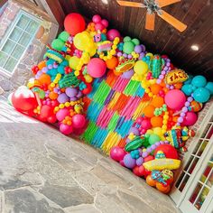 a bunch of balloons and streamers are on the floor in front of a ceiling fan