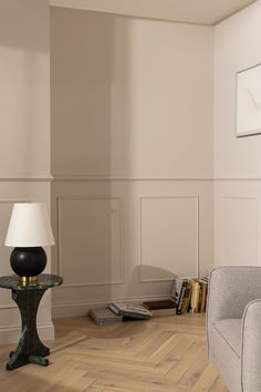 a living room with white walls and wood floors, two lamps on the end tables