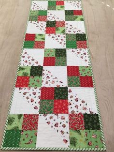 a quilted table runner with red, green and white squares