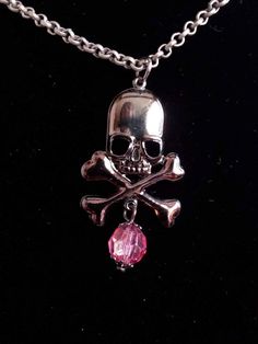 "Gunmetal black skull head with cross  bones pendant with a pink shimmer crystal bead necklace. The chain is matte finish antique silver metal chain. Gothic style great for halloween, birthdays, gifts for her, gifts for him or just to show off your love for skulls.  Measurements: chain 16\" pendant 1 1/2\" bead 8mm" Silver Skull Emo Jewelry, Pink Skull Jewelry For Halloween, Nickel Free Pink Metal Charm Necklaces, Nickel-free Pink Metal Charm Necklaces, Pink Nickel-free Metal Charm Necklaces, Edgy Pink Metal Jewelry, Pink Punk Halloween Jewelry, Pink Gothic Jewelry For Halloween, Edgy Pink Jewelry For Gift