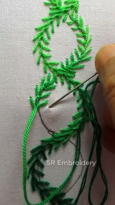 someone is working with green thread on a piece of fabric that has been stitched together