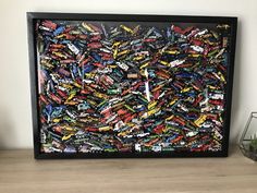 a painting made out of toy cars on a shelf