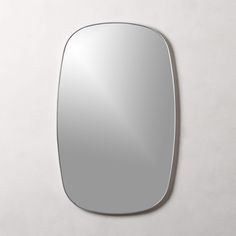 an oval mirror on the wall is shown in front of a plain white wall background