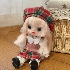 a doll sitting on the floor next to a basket