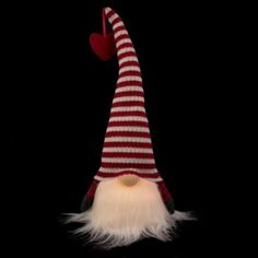 a red and white striped gnome's hat on a black background with a heart