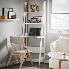 a white chair sitting next to a book shelf