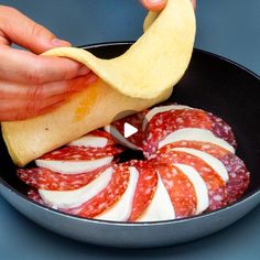 a person is cutting up some meat in a pan with an apple slice on the side