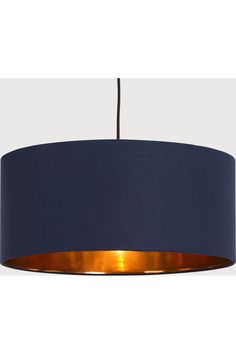 a blue lampshade hanging from a ceiling with a light on it's side