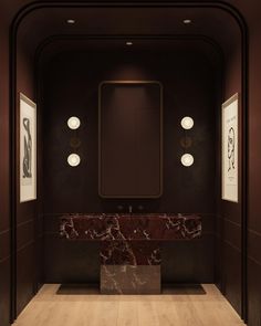 an empty bathroom with marble counter tops and dark walls