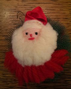 a santa claus ornament hanging on a wooden table