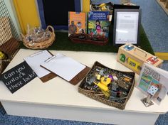 there are many books and toys on the table in front of the children's book display