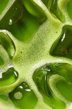 green liquid in a bowl with bubbles and water on the bottom, as seen from above