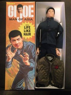 an action figure in a box next to a toy doll wearing a jacket and hat