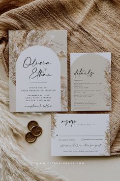 the wedding stationery is laid out on top of a furnishing rug and there are two pieces of paper in front of it