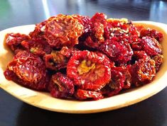 dried goji berries in a wooden bowl on a black counter top, ready to be eaten