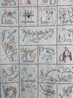 a quilted wall hanging with the names of christmas and other holiday related items on it