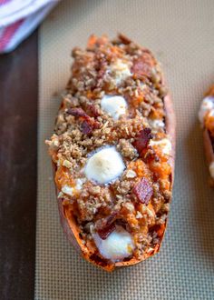 two baked goods sitting on top of a baking sheet next to each other and one is covered in crumbled cheese