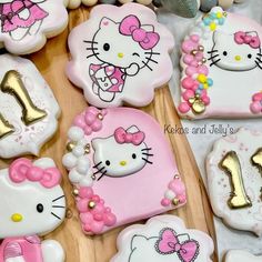 hello kitty cookies are decorated with gold and pink icing for the first birthday girl