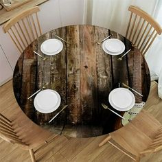 a wooden table with white plates and silverware on it