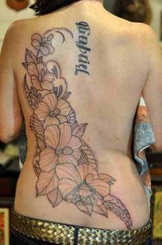 the back of a woman's tattoo with flowers on her lower and upper back