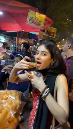 a woman eating food at an outdoor market