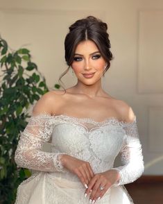 a woman in a white wedding dress posing for a photo with her hands on her hips