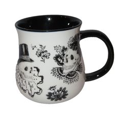 a black and white coffee mug with skulls on it