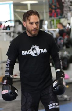 a man in black shirt holding two boxing gloves