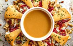 an overhead view of some pizzas with dipping sauce in the middle