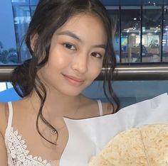 a young woman holding a plate with food on it