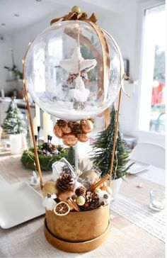 a christmas centerpiece with pine cones, ornaments and other decorations in a glass dome