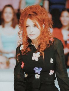 a woman with red hair is sitting down