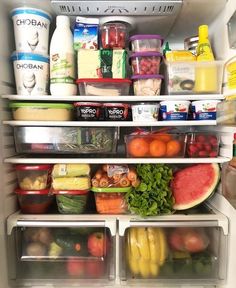 an open refrigerator filled with lots of different types of vegetables and fruit in containers on the bottom shelf