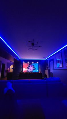 a living room with couches and blue lighting on the ceiling is lit up by remote controls