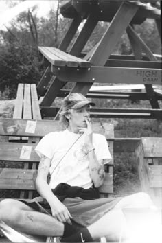 a man sitting on top of a wooden bench