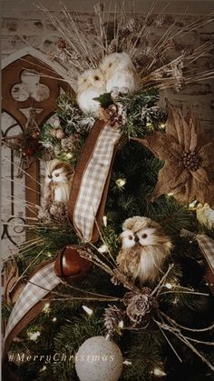 an old fashioned christmas tree decorated with owls and pine cones